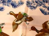three ducks flying in the air near a pine tree