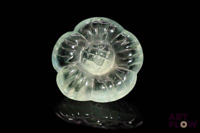 a glass object that looks like a flower on a black surface