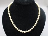 un collier de perles blanches sur un mannequin noir