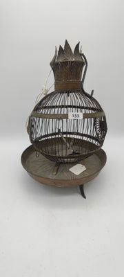 a bird cage with a bird inside of it on a plate