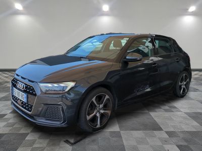 a grey audi suv parked in a garage with a checkered floor