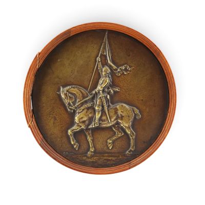 a bronze plaque of a man on a horse with a flag