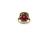 a close up of a gold ring with a pink stone