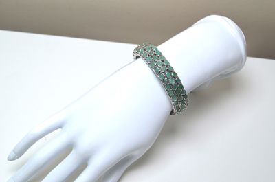 bracelet with green stones on a white mannequin hand
