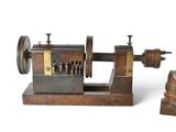 a small machine that is sitting next to a stack of coins