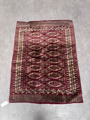 un tapis rouge et or posé sur un sol gris