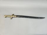 a close up of a knife on a white surface with a black handle
