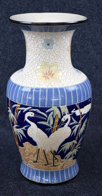 un vase bleu orné de motifs blancs et dorés