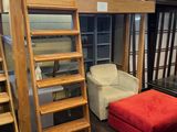 un lit mezzanine avec un pouf rouge au milieu de la pièce