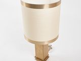 brass table lamp with a white shade on a wooden base