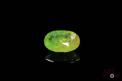 a close up of a green jade stone on a black surface