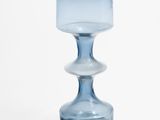 a blue glass vase sitting on top of a white table