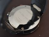 a close up of a watch on a brown surface