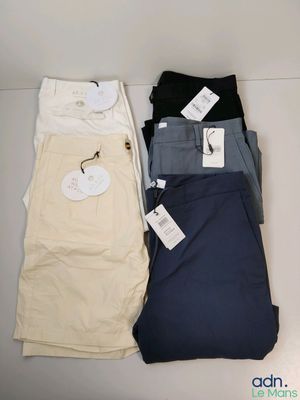 trois paires de pantalons pour homme posées les unes à côté des autres sur une table