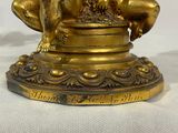a gold statue of a dog sitting on top of a table