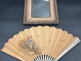 une photo représentant un cadre et un ventilateur posés sur une table