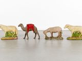 five figurines of animals that are standing in a row