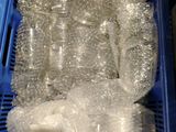 a blue basket filled with plastic bottles and plastic bags