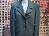 a suit on a mannequin stand in front of a wall