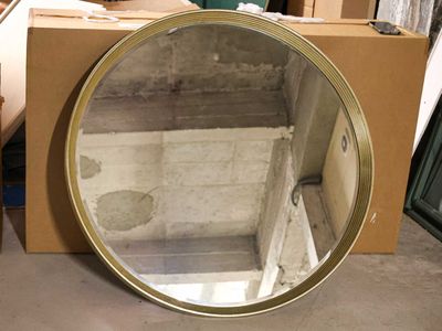 a mirror that is sitting on the floor in front of a box
