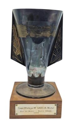 a glass vase that is sitting on a wooden base