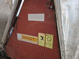 une porte rouge recouverte d'autocollants, dans un coin de la pièce