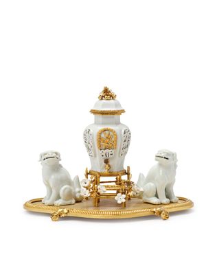 an image of a white and gold figurine with a clock and two dogs