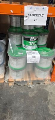 several buckets of paint are stacked on a shelf in a warehouse