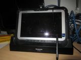 a tablet computer sitting on a desk with a pen in front of it