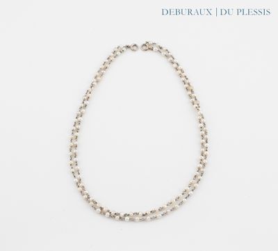 a close up of a necklace on a white surface