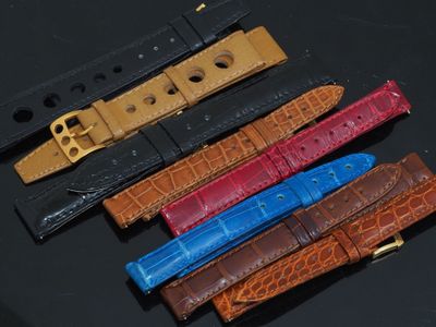 quatre bracelets de montre en cuir de couleurs différentes sur un fond noir
