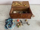 une boîte en bois remplie de bijoux posée sur une table en marbre