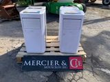 deux ordinateurs posés sur une palette dans un parking