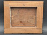 an old wooden picture frame with a small piece of wood in it