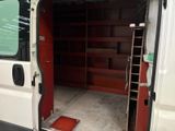 a white van with a red door and shelves in the back of it