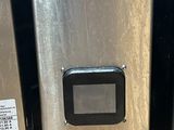 a stainless steel refrigerator next to a metal trash can on the floor