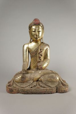 une statue en or représentant un Bouddha assis sur un rocher