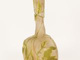 a glass vase that has a green and yellow design on it