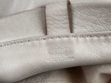 the inside of a white leather jacket with a zippered pocket