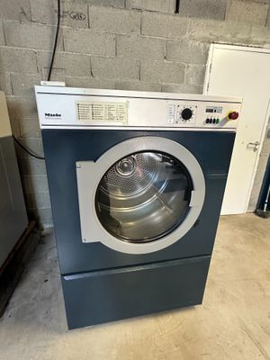 a close up of a washer sitting in a room next to a refrigerator