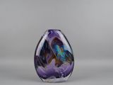 un vase en verre violet et bleu orné d'un papillon