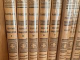 several books are lined up on a shelf in a bookcase