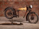 a old motorcycle that is sitting in front of a brick wall