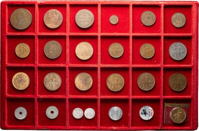 an assortment of coins in a red display case on a white background