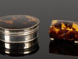 une carapace de tortue et un coffret en argent posés sur un fond noir