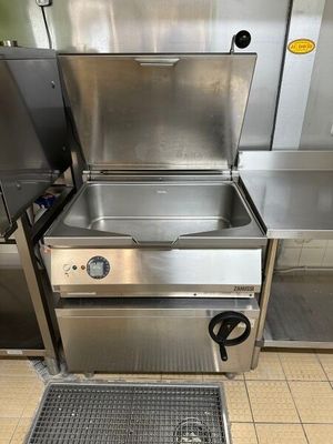 une cuisinière en acier inoxydable et un évier dans une cuisine professionnelle