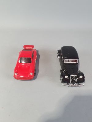 two toy cars sitting next to each other on a white surface
