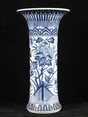 a blue and white vase sitting on a black surface