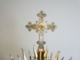 a golden cross on top of a silver and gold crown