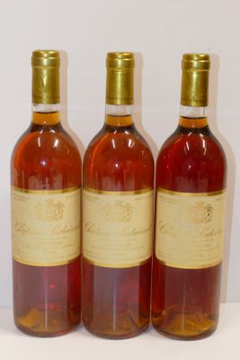 trois bouteilles de vin sont alignées sur une surface blanche